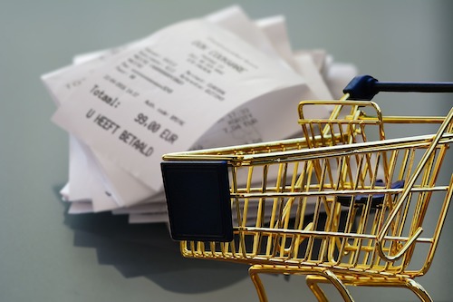 A shopping trolley with receipts in background